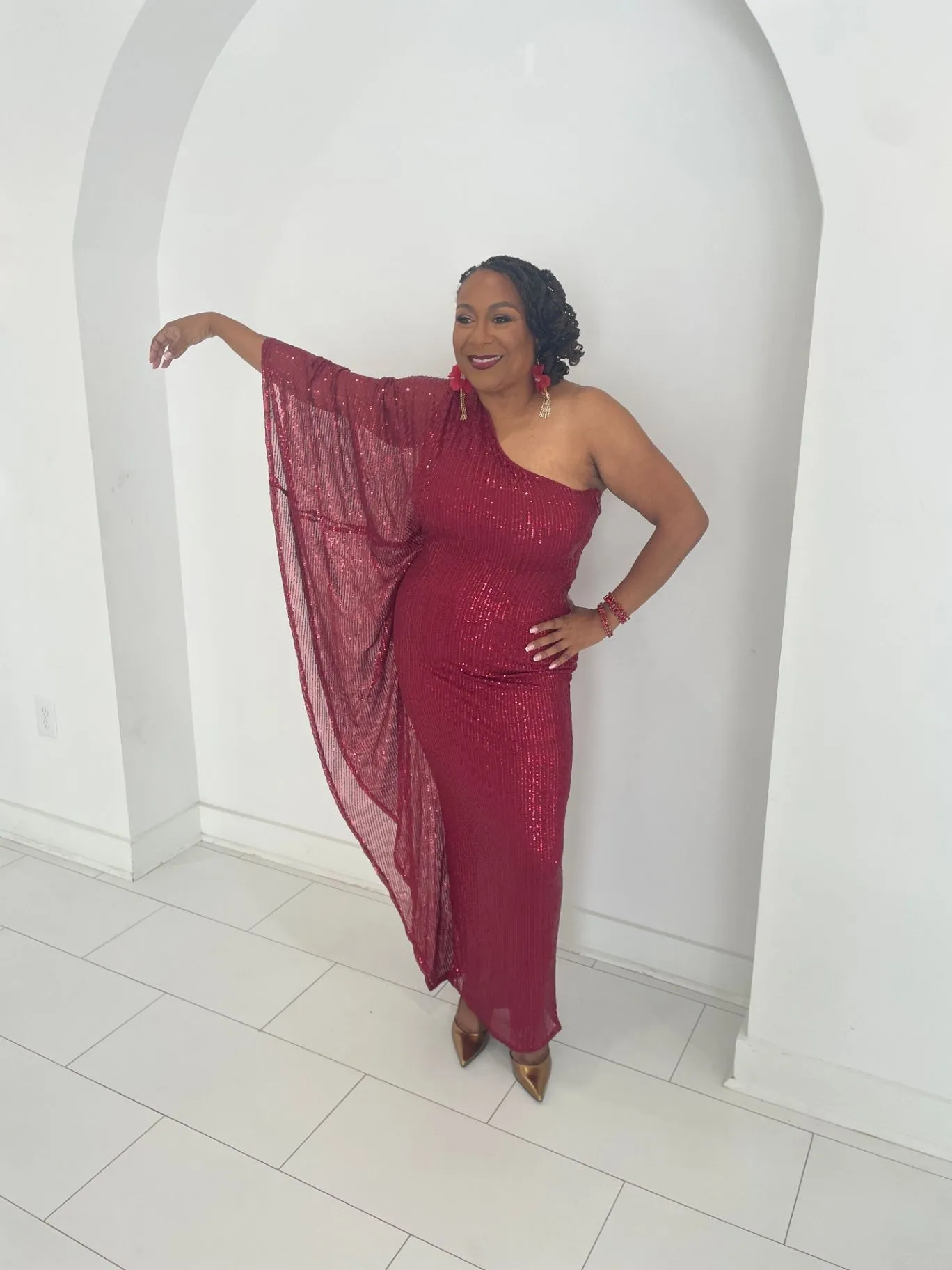 Burgundy sequined one-shoulder gown styled for a standing portrait