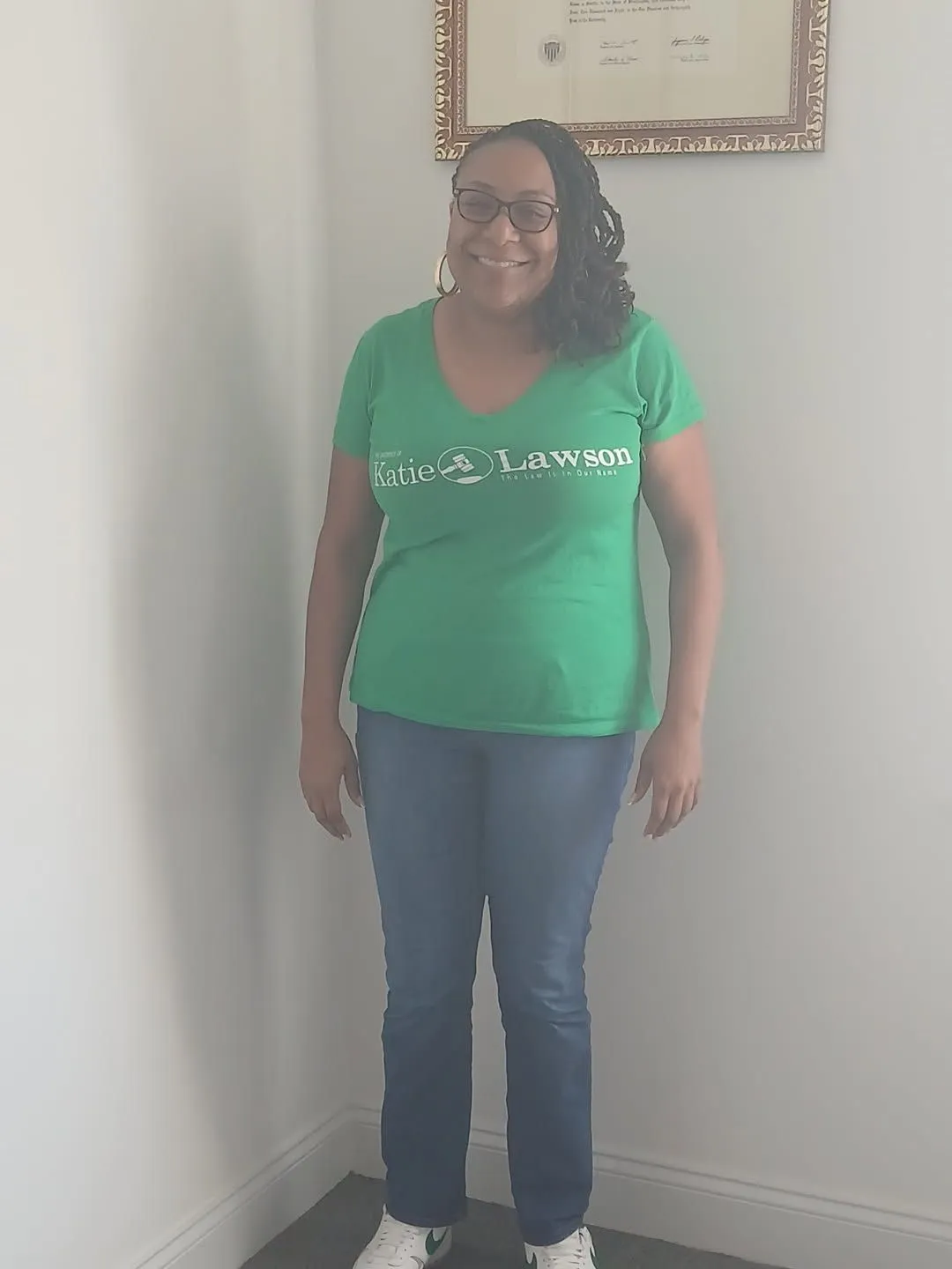Green T-shirt, jeans, and sneakers styled for a standing portrait