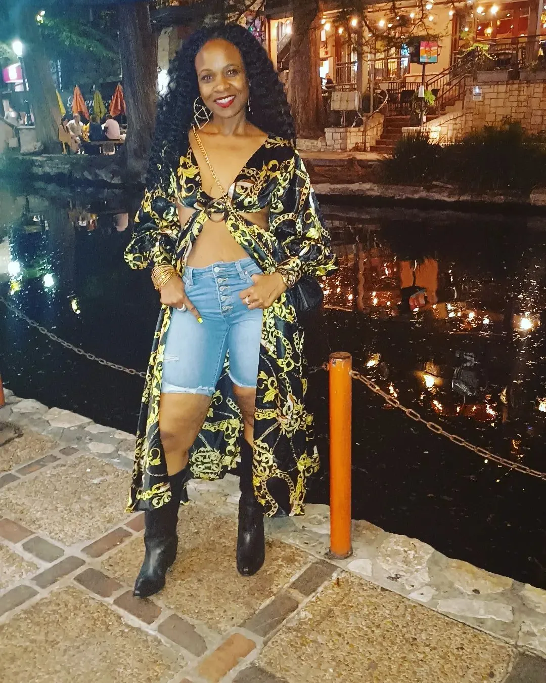 Black and gold chain-print duster styled with denim shorts and tall boots