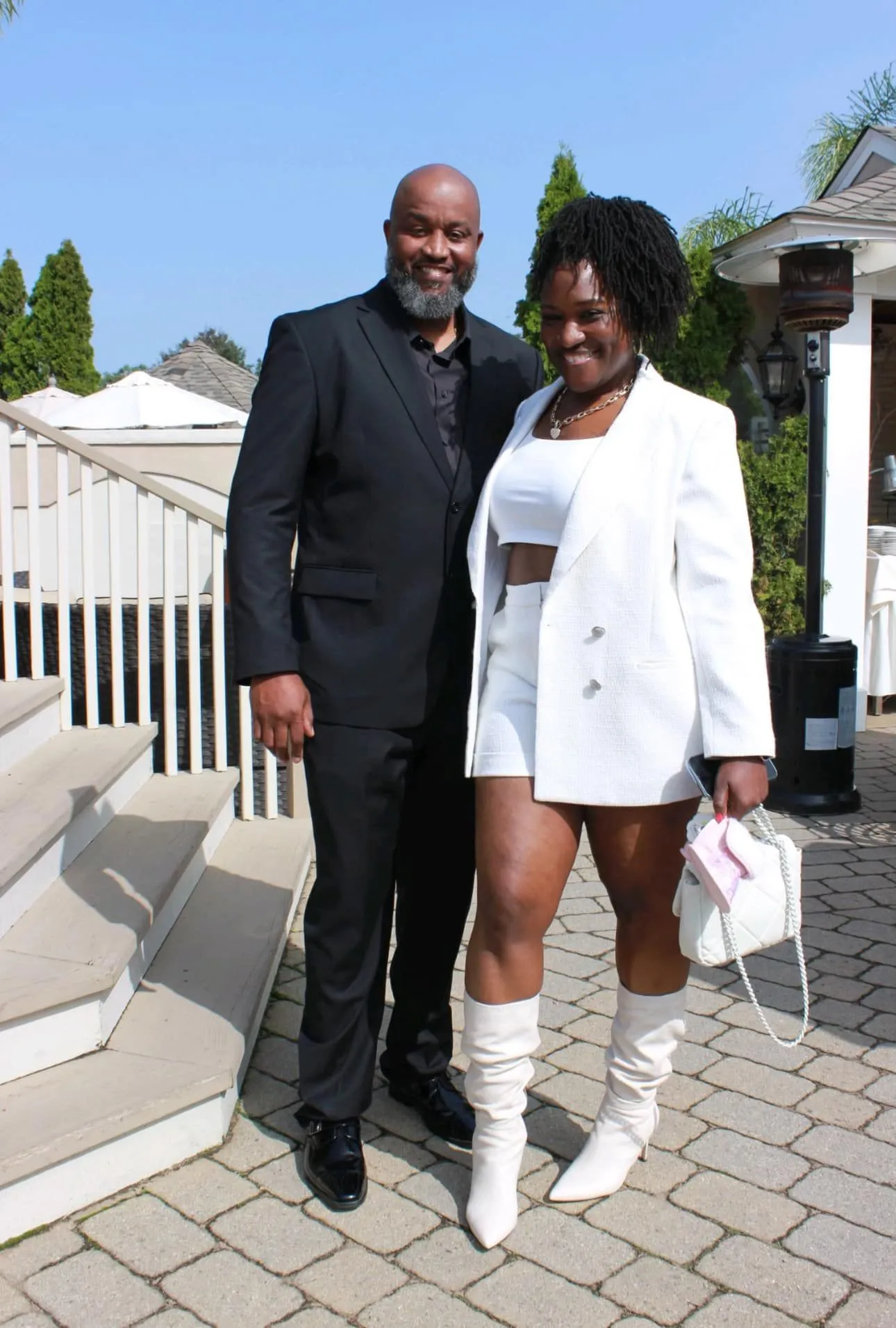 Formal couple posing together on a sunny patio